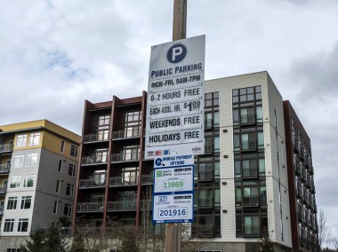 Redmond, WA USA - Mart 2021: Şehir merkezindeki bir park parkında bir kamu park ücreti listesi tabelasının açılı görünümü.