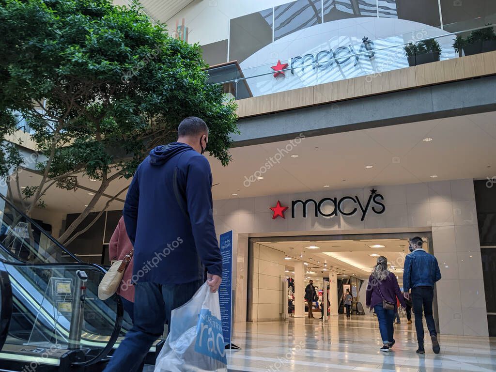 Bellevue, WA USA - circa March 2021: Shoppers with face masks approaching the entrance of a Macy's department store inside the Bellevue Mall during covid 19.