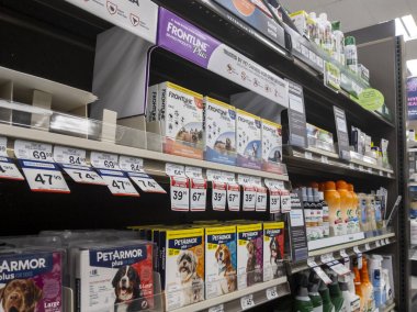 Kirkland, WA USA - circa April 2021: View of shelves stocked with flea and tick treatments for cats and dogs inside a Petco pet supply store. clipart
