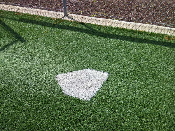 Focus on a practice diamond inside a batting warm-up area at a baseball field