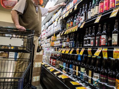 Woodinville, WA USA - Nisan 2021: Haggen bakkalındaki el yapımı bira reyonunda yaşlı bir adamın alışveriş yaparken görüntüsü.