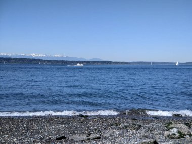 Güneşli ve bulutsuz bir günde Pasifik Okyanusu 'nun karşısındaki Olimpiyat dağlarının güzel manzarası.