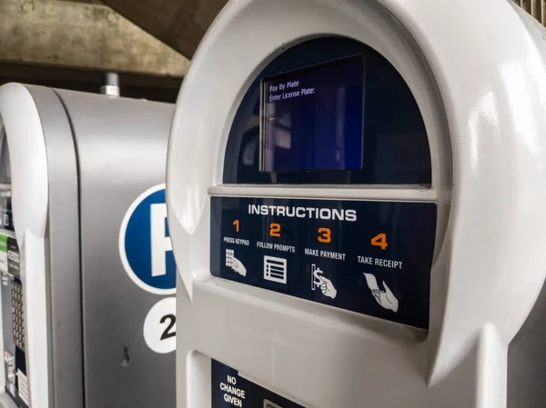 Close up view of an electronic pay-to-park machine inside a parking garage near a university
