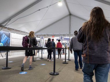 Seattle, WA USA - Mayıs 2021: Lumen Field 'da covid 19 aşısını almadan önce güvenlik kontrolü için sırada bekleyen insanların görüntüsü