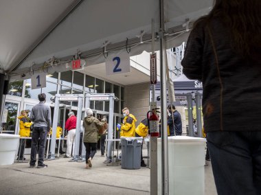 Seattle, WA USA - Mayıs 2021: Lumen Field 'da covid 19 aşısını almadan önce güvenlik kontrolü için sırada bekleyen insanların görüntüsü
