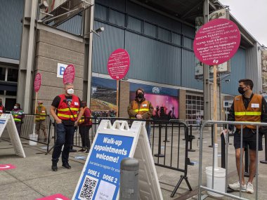Seattle, WA USA - Mayıs 2021: Lumen Field 'da covid 19 aşısını almadan önce güvenlik kontrolü için sırada bekleyen insanların görüntüsü