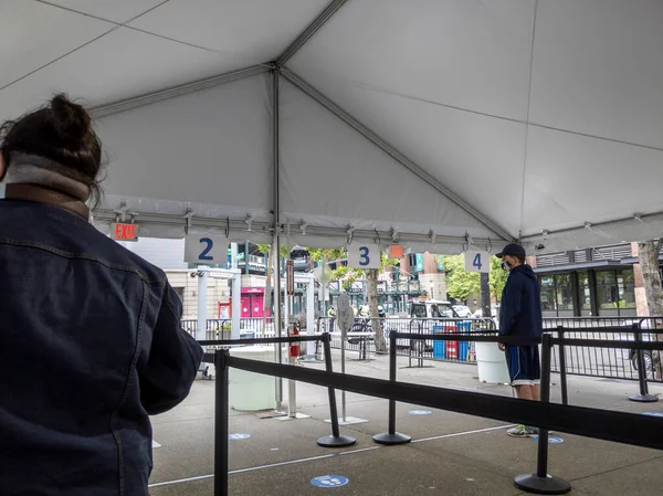 Seattle, WA USA - Mayıs 2021: Lumen Field 'da covid 19 aşısını almadan önce güvenlik kontrolü için sırada bekleyen insanların görüntüsü