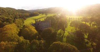 Aerial view of Glenarm Castle and sun throught trees in Ireland 