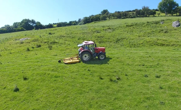 Traktor Toppning Gräs Ett Fält — Stockfoto