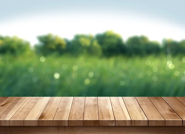 Mesa de madera y hierba verde fondo borroso — Foto de Stock