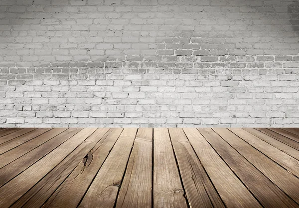 Bord av trä med vita tegel vägg bakgrund — Stockfoto
