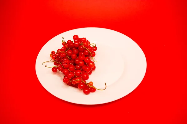 Красные фрукты в белой тарелке — стоковое фото