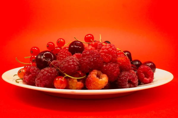 Красные фрукты в белой тарелке — стоковое фото