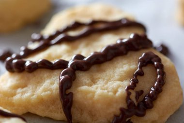 Yeni pişmiş Noel kurabiyelerinin üzerine çikolata döküyorum.