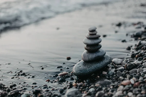 Gün batımında kumsalda taş piramit, güzel deniz manzarası, dinlenme ve deniz kenarında tatil konsepti., 