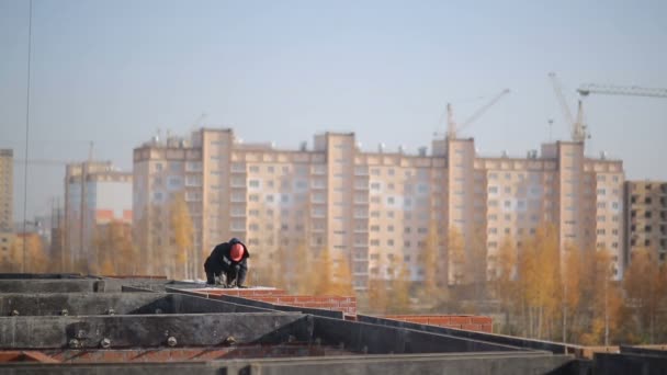 Bouwers zijn op de bovenste verdieping van een huis van baksteen — Stockvideo