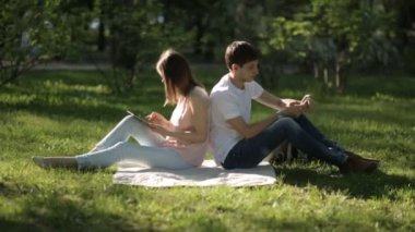 Arka arkaya ekose parkta oturan kız ve erkek. uzak ihtimal.