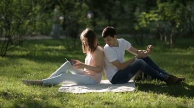 Arka arkaya ekose parkta oturan kız ve erkek. uzak ihtimal.