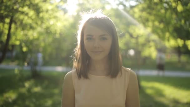 Étonnamment belle femme dans un chemisier lumineux sur fond de parc d'été — Video