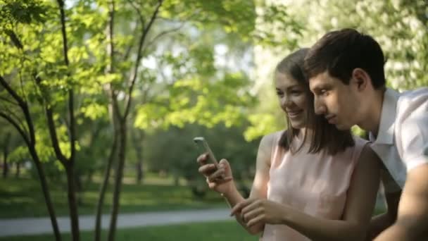 Menina feliz com seu namorado fotos de árvore verde — Vídeo de Stock