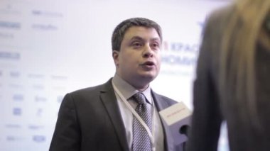 Yerel bir televizyon kanalına röportaj veren işadamı. Muhabir çeşitli sorular soruyor. Uluslararası ekonomik forumda basın duvarı.