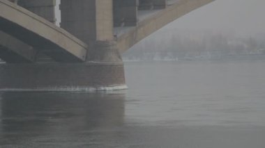 Kışın Rusya'da bir nehir üzerinde yol köprüsü. Sibirya don. Nehir buzla kaplıydı. Sibirya şehrinde çok soğuk su. Zor iklim koşulları.