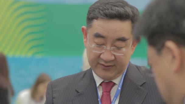 Dospělý asijský muž stojí a mluví se svými partnery. Mezhreždunarodnyj ekonomické fórum, konverzace. Nadcházející jednání. Soukromá ujednání. — Stock video