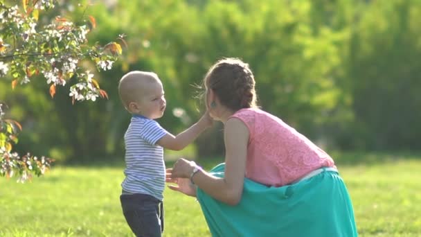 Küçük mutlu bir çocuk annesi baloncuklarla üfleme. — Stok video