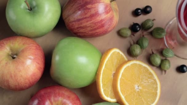 Frutas en la mesa de madera. Manzanas, kiwis, naranja, grosella . — Vídeo de stock