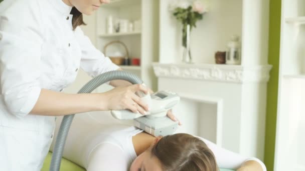 Donna sdraiata sul letto in un salone e che riceve la procedura di massaggio lipo — Video Stock