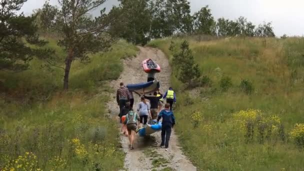Rusland, Siberië 2014: Mannen dragen een rubberboot dobbert in de bergen. Toeristen — Stockvideo