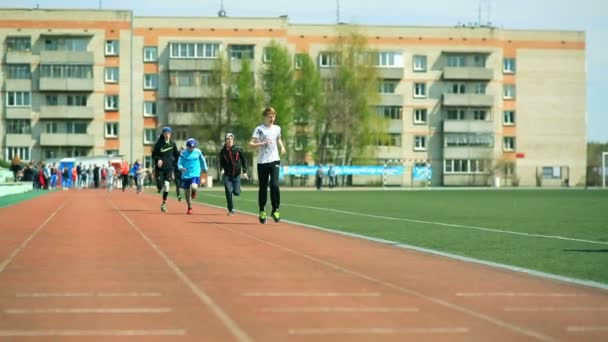 Russia, Novosibirsk, 2015: Students run around the stadium. — Stock Video