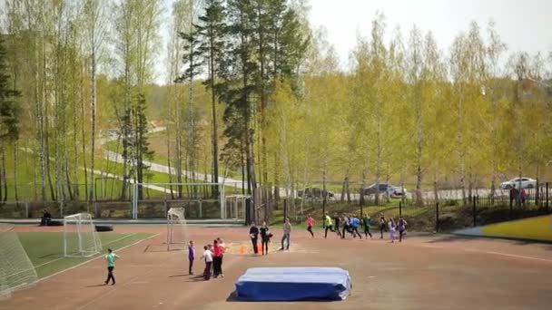 Россия, Новосибирск, 2015: Студенты бегают по стадиону . — стоковое видео
