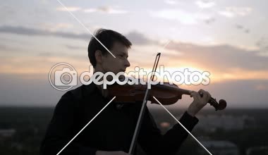 Kemancı müzik aleti onun omzuna koyar ve oynamaya başlar