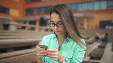 Uzun saçlı güzel kız telefonda bir mesaj yazıyor