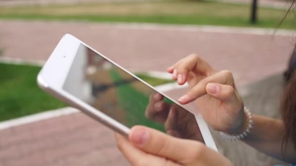 Mujer incierta utiliza una tableta de pantalla táctil. La tableta en las manos — Vídeo de stock