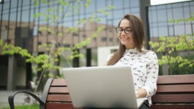Kız dizüstü ekrana bakar ve klavyede yazarak