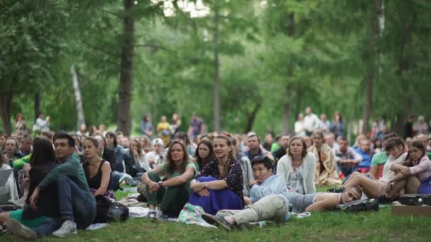 Rusland, Novosibirsk, 2016: Mensen zitten op het gras in een stadspark — Stockvideo