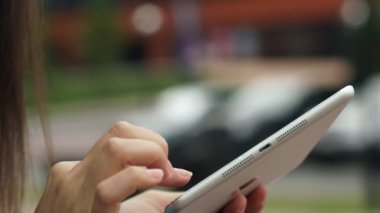 Womens hands with the white tablet. Using a touchscreen tablet, slow