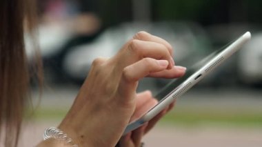 Womens hands with the white tablet. Using a touchscreen tablet, slow