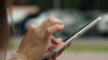 Womens hands with the white tablet. Using a touchscreen tablet, slow