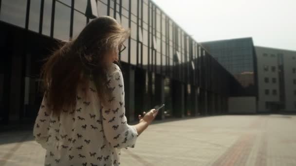 Schönes Mädchen, das auf der Straße aufwacht und ein Smartphone benutzt — Stockvideo