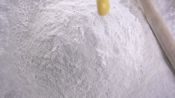 Egg dropping into flour, slow motion. lour Products. Bakery products. — Stock Video