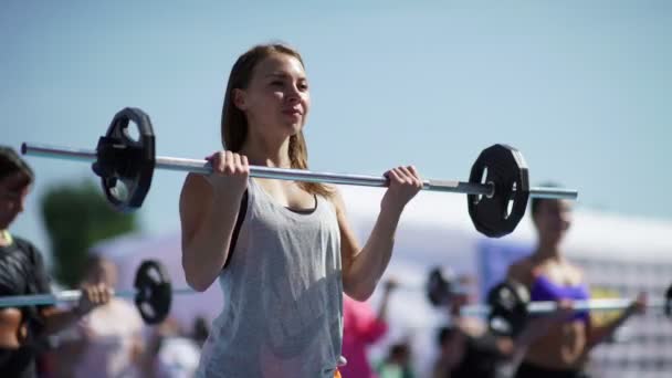 Rusland, Novosibirsk, 2016: Sport meisje legt de lat op haar borst. — Stockvideo