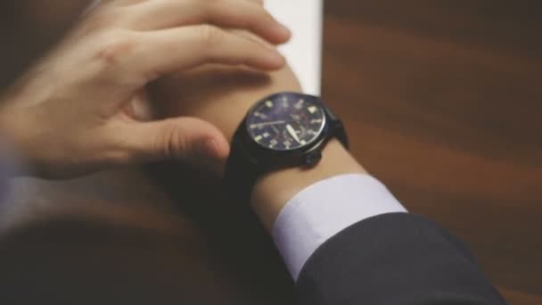 Businessman checking wrist watch. The watch on the hand