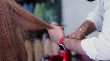 Kuaför çalışıyor. Eller erkek stilist. Tarak saç biter.