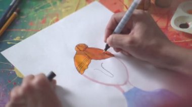 İşteki sanatçı. Sanatçının elinde keçeli kalem.