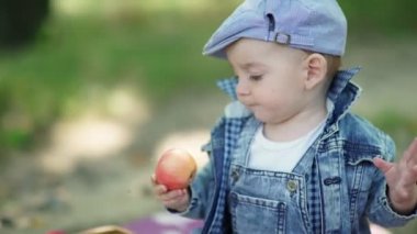 Elmalar yakın sepet. Doğada neşeli bir çocuk. Denim takım elbise li ve şapkalı toddler