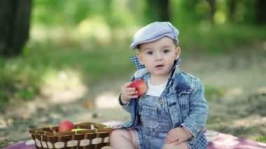 Denim takım elbiseli ve elinde elma tutan bir kap Toddler