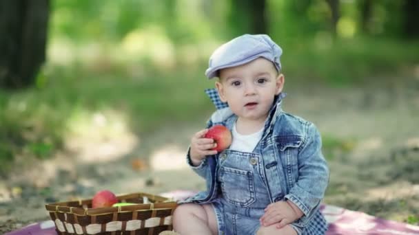 Tipegő farmer öltönyt és egy sapkát gazdaság almát a kezében — Stock videók